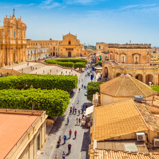 Cityscape of Noto. View of the central street with walking tourists. Province of Syracuse, Sicily, Italy