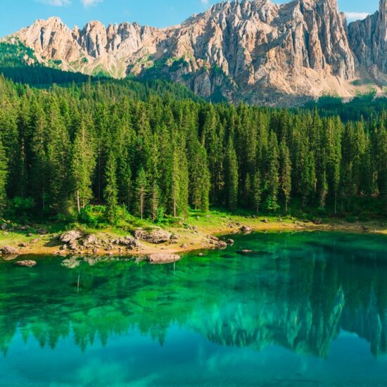 Beautiful turquoise Alpine lake Carezza or Lago di Carezza in Dolomites mountains, South Tyrol, Italy