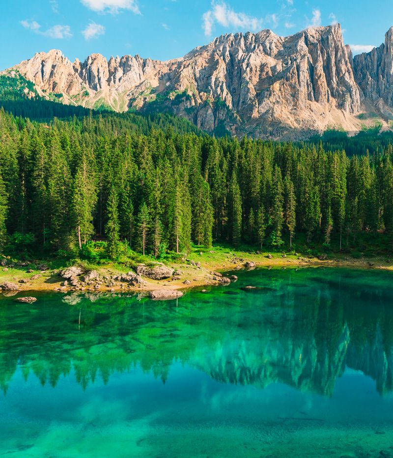 Beautiful turquoise Alpine lake Carezza or Lago di Carezza in Dolomites mountains, South Tyrol, Italy