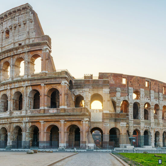 Ancient Colosseum Amphitheater in Rome city, Italy illuminated by soft morning light at sunrise with nobody. Italian architecture. Popular touristic and travel landmark