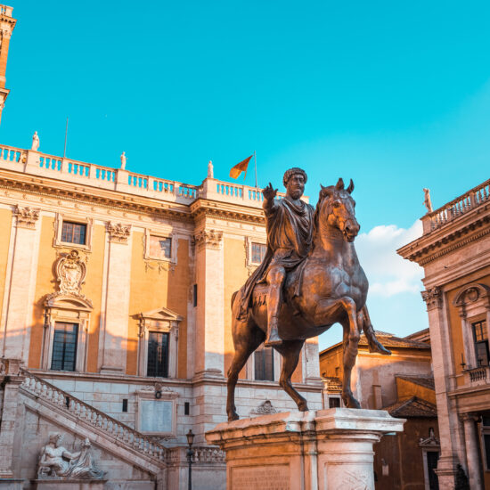 Bronze statue of Emperor Marcus Aurelius on horseback in the center of Piazza del Campidoglio in Rome with the town hall