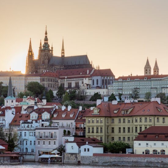 Cityscape and beautiful architecture of Prague displaying Lobkowicz Palace against a glowing sun